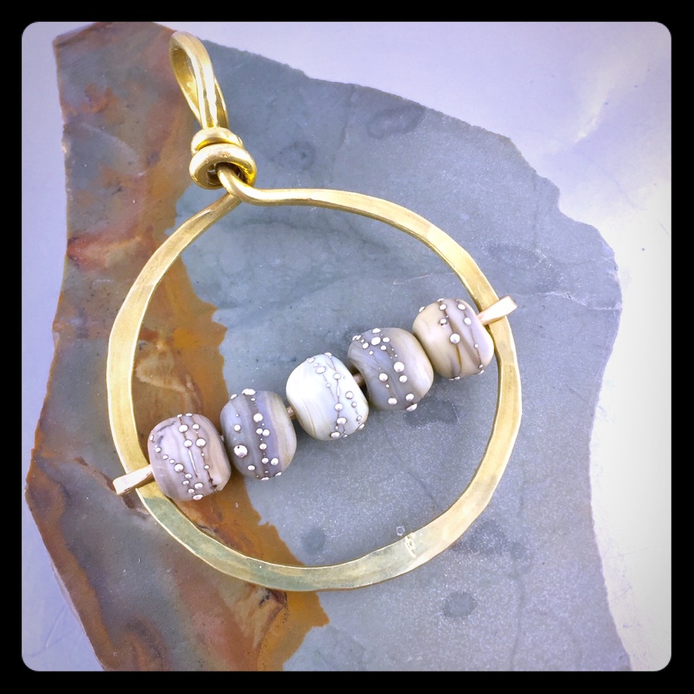 Glass, sterling silver, and brass pendant